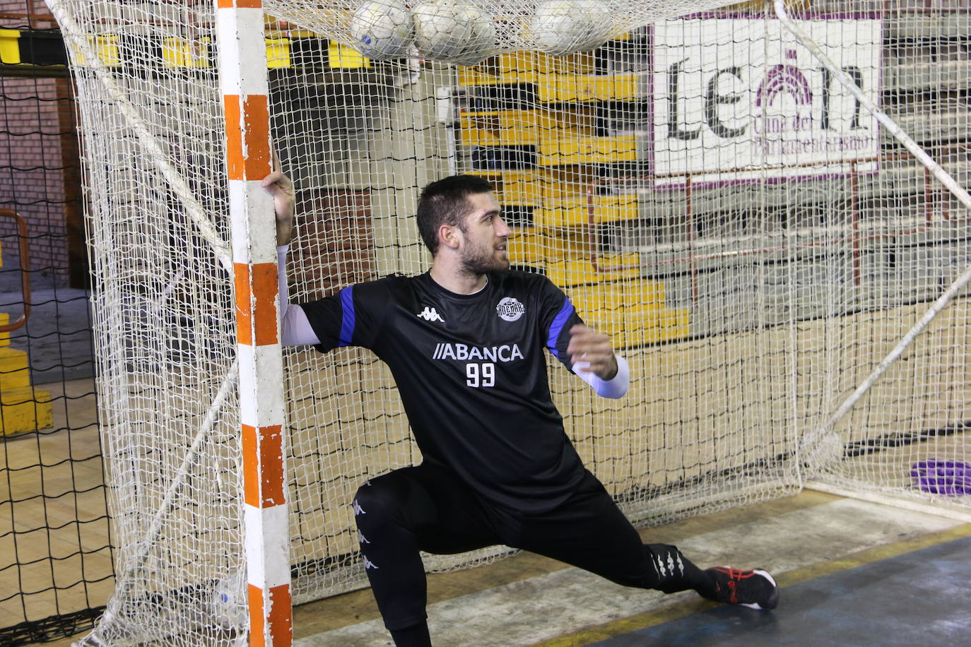 La plantilla del Ademar realiza flexiones en medio de la cancha del Palacio de los Deportes. 