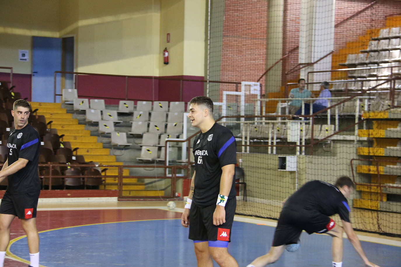 La plantilla del Ademar realiza flexiones en medio de la cancha del Palacio de los Deportes. 