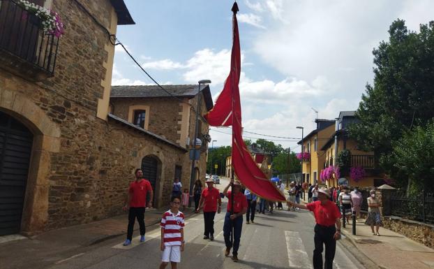 Procesión bajo palio de la custodia con la Sagrada Forma, precedida por el pendón local portado por miembros de la Asociación de Pendoneros de San Lorenzo.