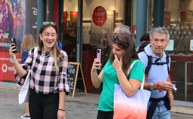 Dos jóvenes graban la manifestación de los pensionistas en la plaza de Botines. 