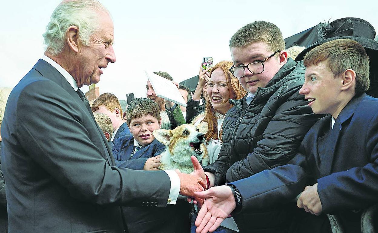 Carlos III saluda a un grupo de adolescentes a su llegada al castillo de Hillsborough, en Belfast.