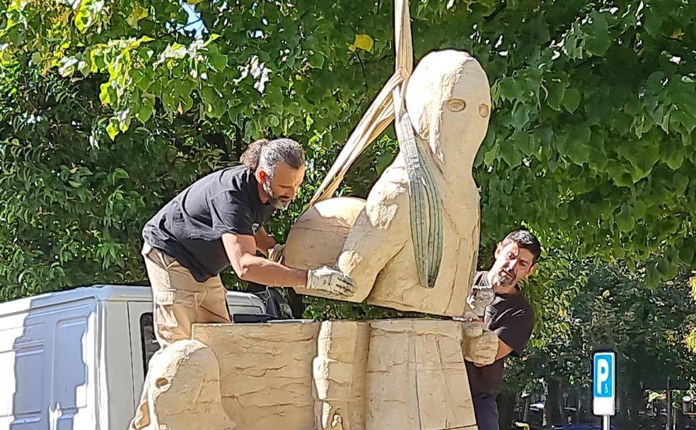 Una de las figuras que forman parte de la escultura es colocada por los operarios municipales frente a Correos.