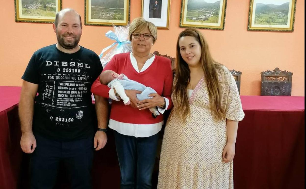 Manuel, en el centro de la imagen en los brazos de la alcaldesa del municipio, y sus padres, Manolo y Lorena, posan en el Ayuntamiento de Murias de Paredes.