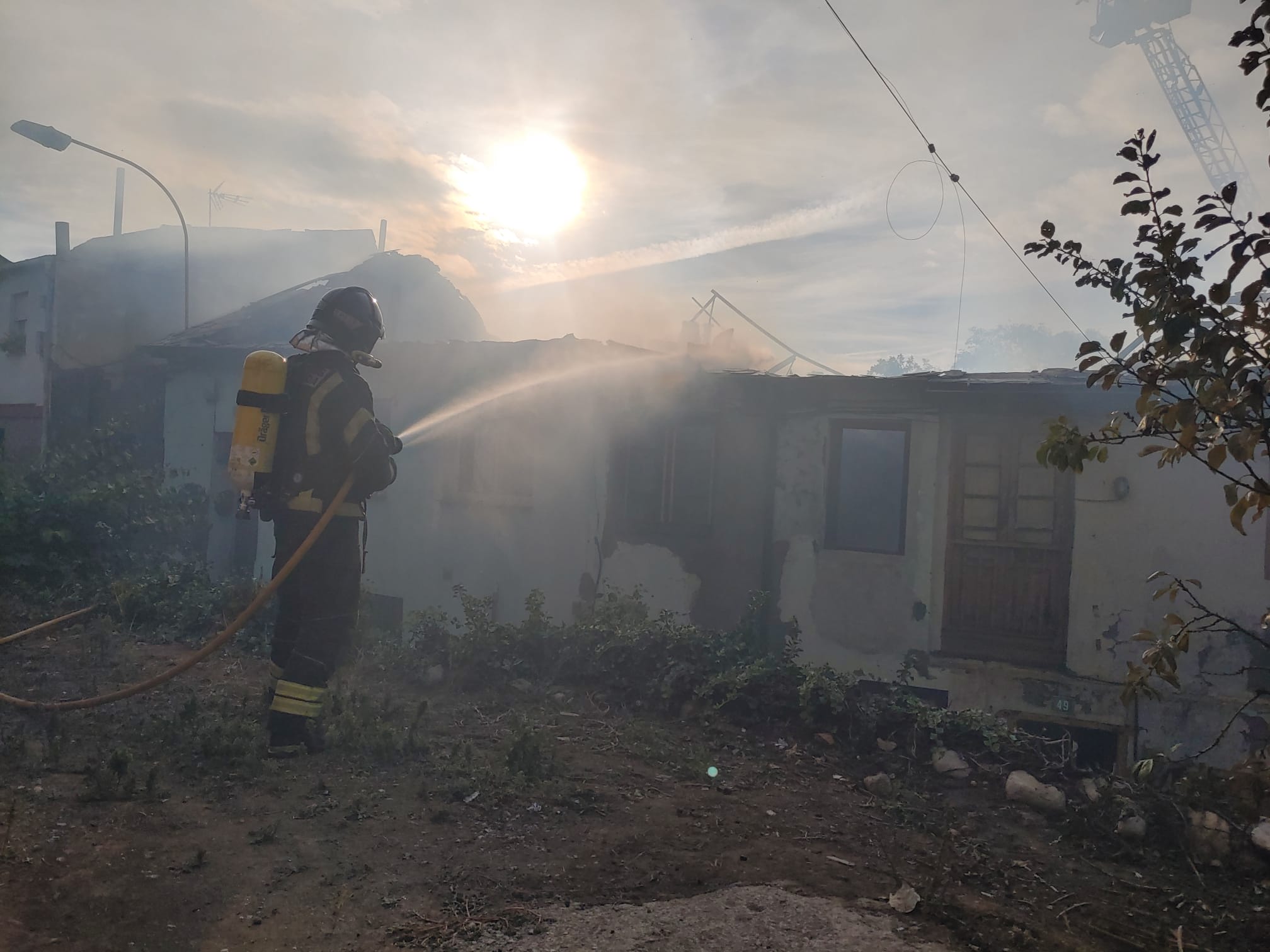 Los Bomberos de Pofnerrada trabajan en la extinción de un intenso fuego que se originaba en una casa de Villalibre y de lque todavía se desconocen sus causas