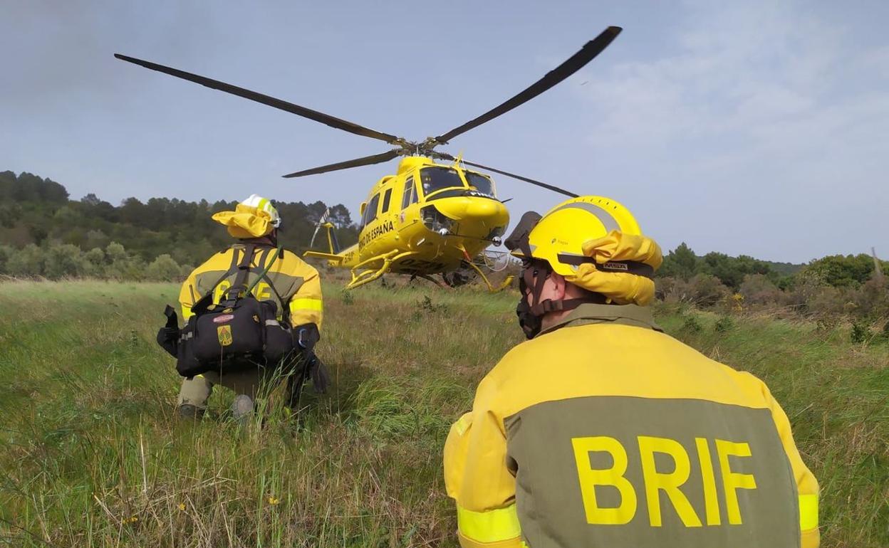 Brigadistas forestales, junto a su helicóptero, durante una intervención. 