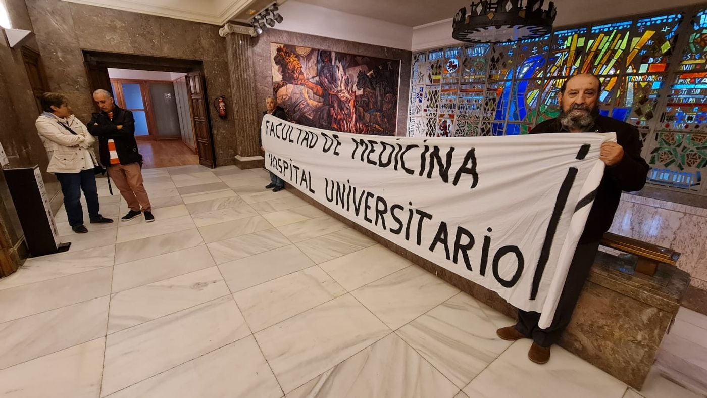 Los leonesistas Félix Pérez Echevarría 'Cheva' y Paco León llevan a las puetas del pleno municipal una reivindicativa pancarta por la Facultad de Medicina para León. «Es un derecho de León y los leoneses y llevamos dos décadas exigiendo que se instale en León», aseguran.