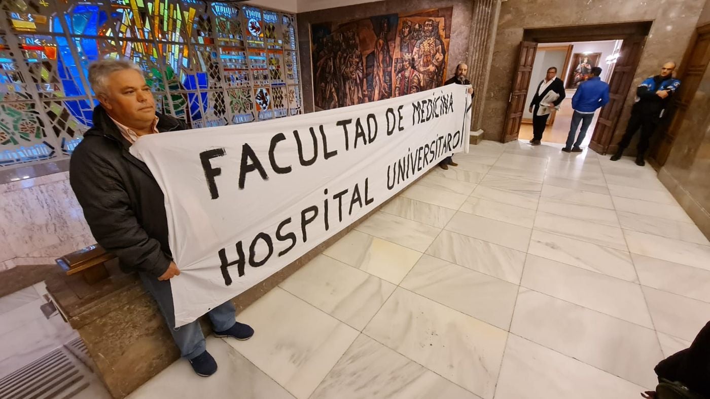 Los leonesistas Félix Pérez Echevarría 'Cheva' y Paco León llevan a las puetas del pleno municipal una reivindicativa pancarta por la Facultad de Medicina para León. «Es un derecho de León y los leoneses y llevamos dos décadas exigiendo que se instale en León», aseguran.