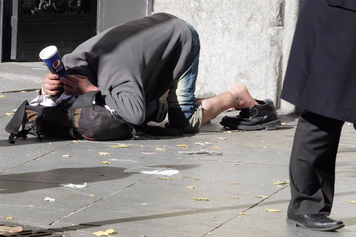 Un hombre pide limosna en la calle. 