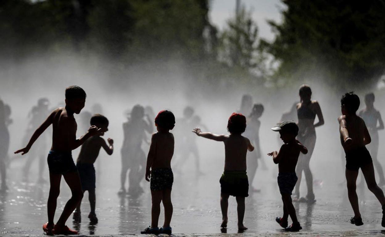 Niños refrescándose.