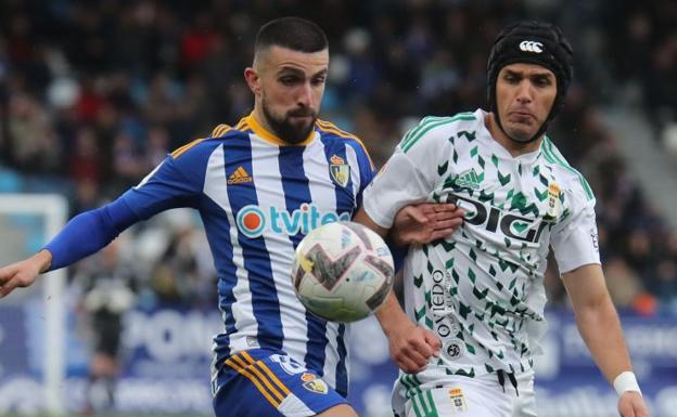 Galería. Agus Medina pugna con Luismi por un balón.