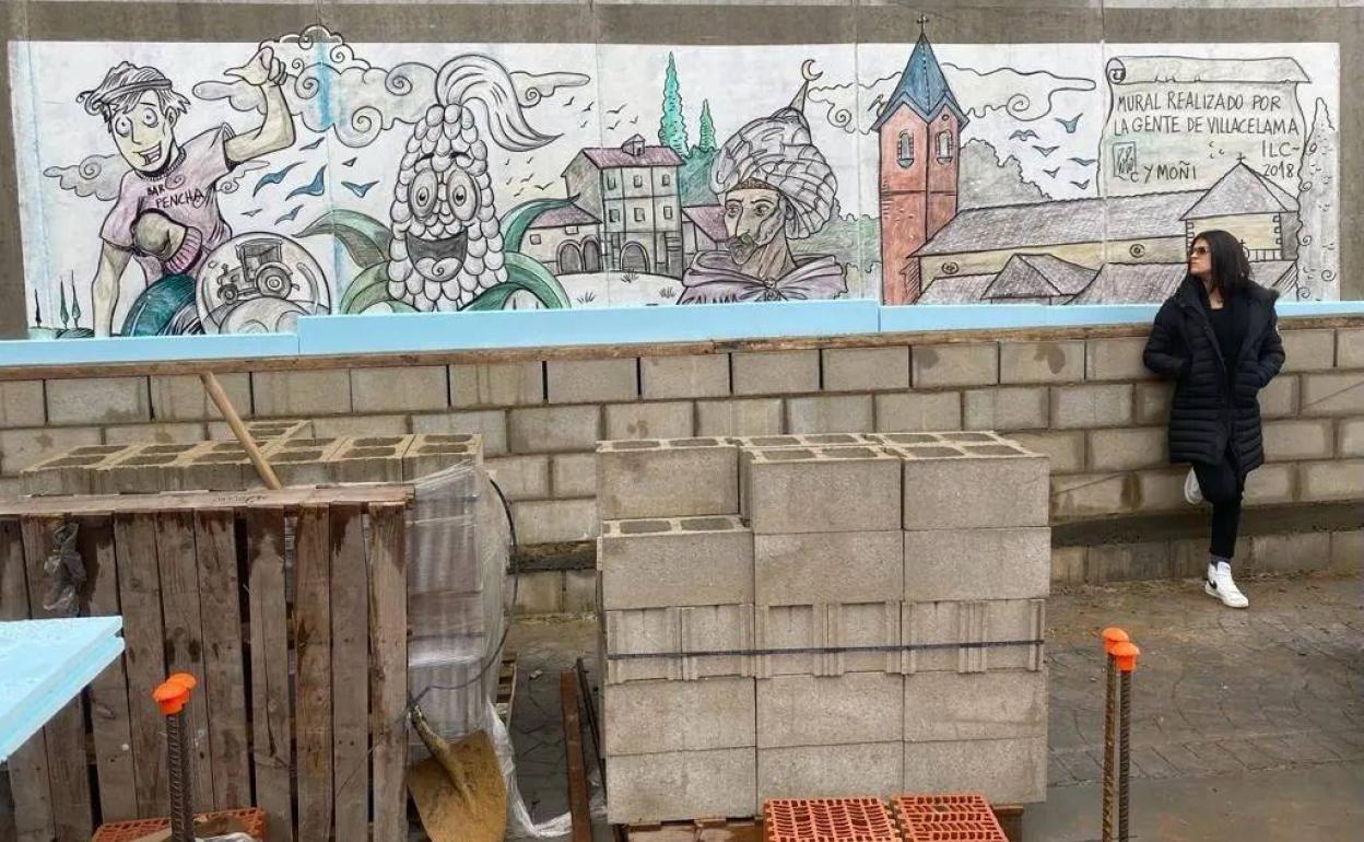 Laia, hija de Lolo, posa junto al mural de su padre que las obras de Villacelama ya han comenzado a tapar.