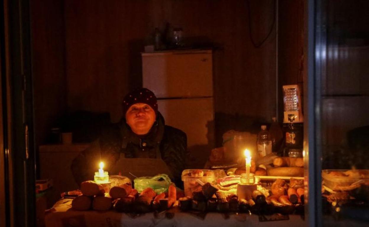 Un vendedora ilumina su puesto con velas en una calle de Odesa.