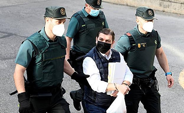 Román llega custodiado a la Audiencia de Madrid durante el juicio.