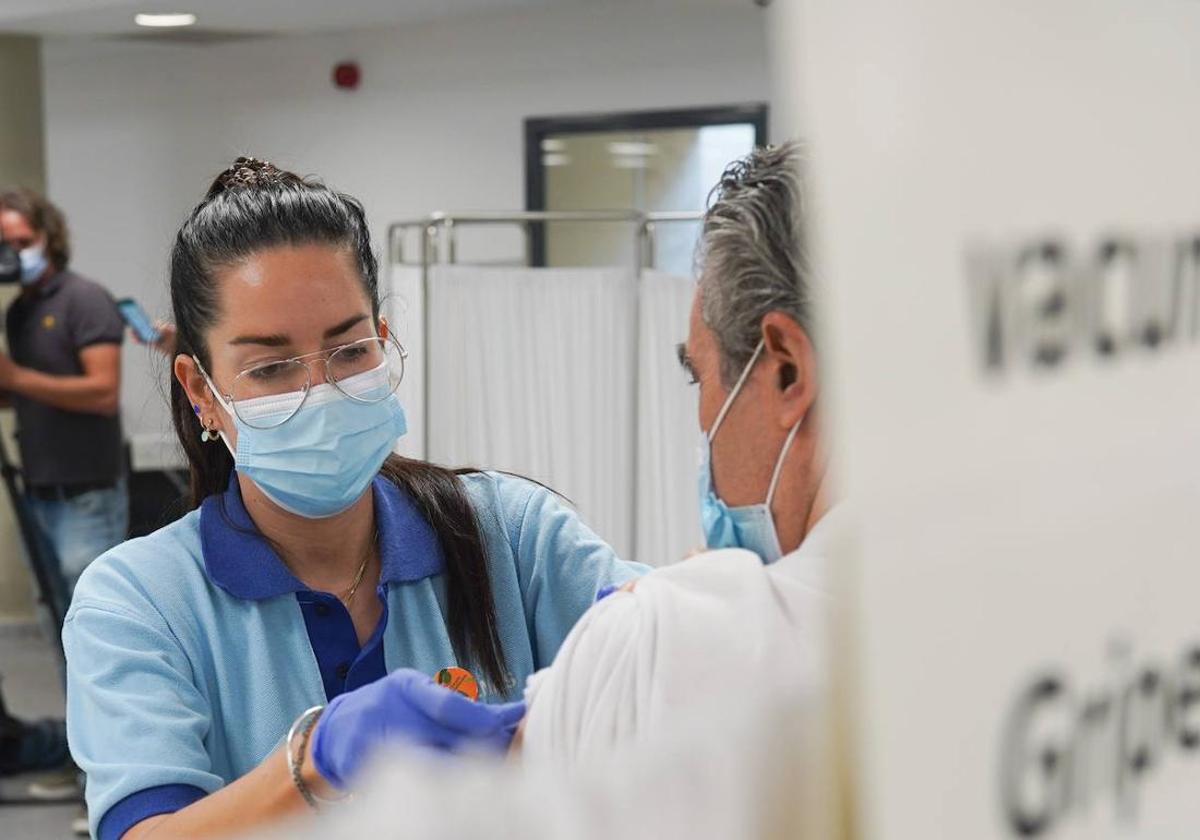 Una enfermera vacuna a una persona de la gripe.