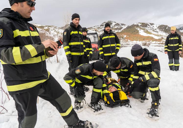 Imagen principal - Efectivos del BIEM V de la UME realizan un ejercicio de instrucción de rescate de víctimas tras una avalancha de nieve. 