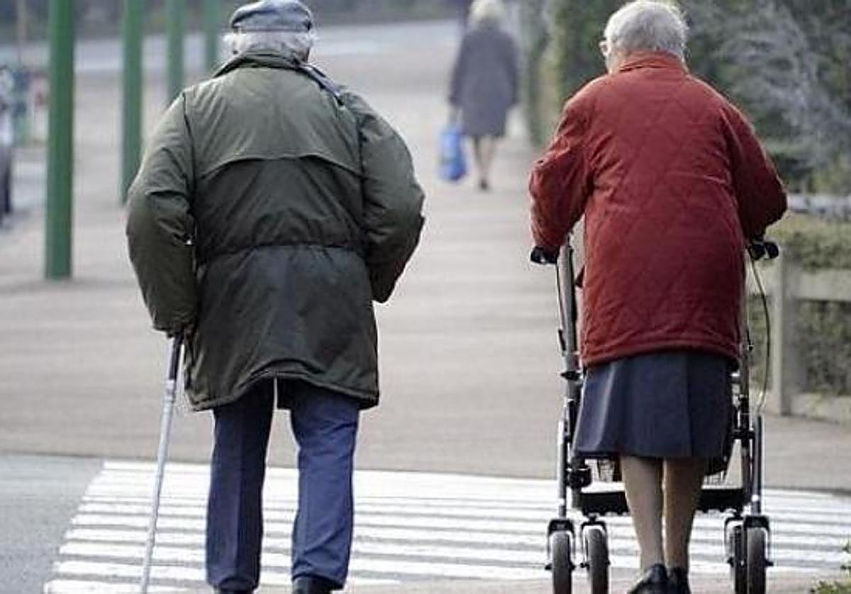 Una pareja de ancianos camina por las calles de León.