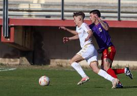 Un jugador del Júpiter Leonés intenta zafarse de la marca del defensa del Palencia CF en una imagen de archivo.