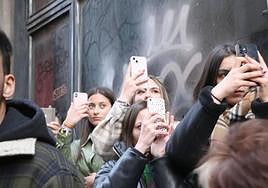Un grupo de jovenes fotografía el paso de La Morenica en la primera procesión de la Semana Santa de León.