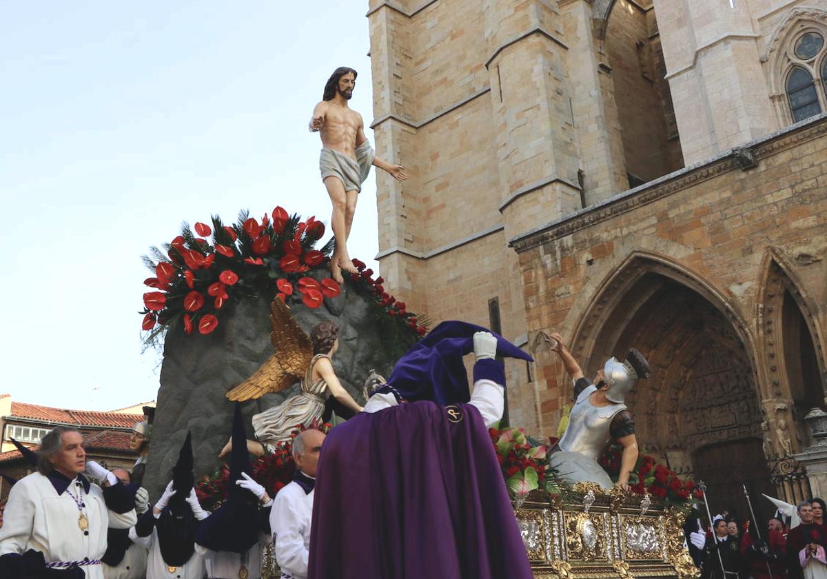 Los hermanos de Jesús Divino Obrero se retiran los capillos ante la imagen del resucitado.
