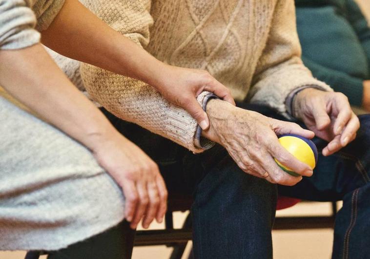 Una monitora y un enfermo de parkinson durante una sesión de terapia.