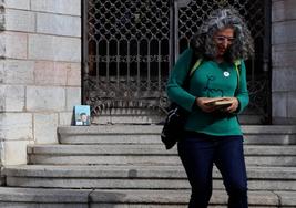 Eliana Abella, responsable de la biblioteca de la Escuela Oficial de Idiomas de León, deja un libro en Botines en una iniciativa de 'bookcrossing'.