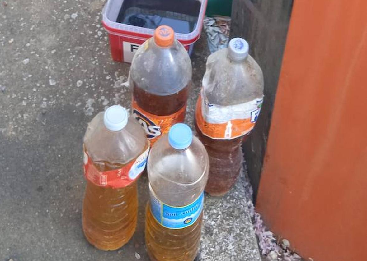 Botellas frente a los contenedores en Chozas de Abajo.