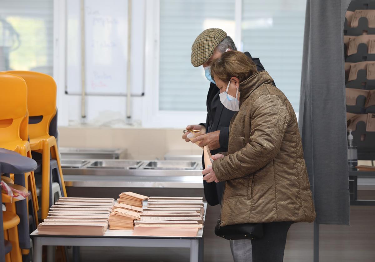 Dos ancianos ejercen su derecho al voto.