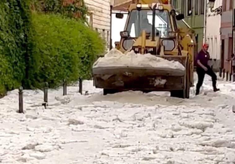 Maquinaria pesada retira el rastro del granizo durante la jornada de este lunes en La Pola de Gordón.