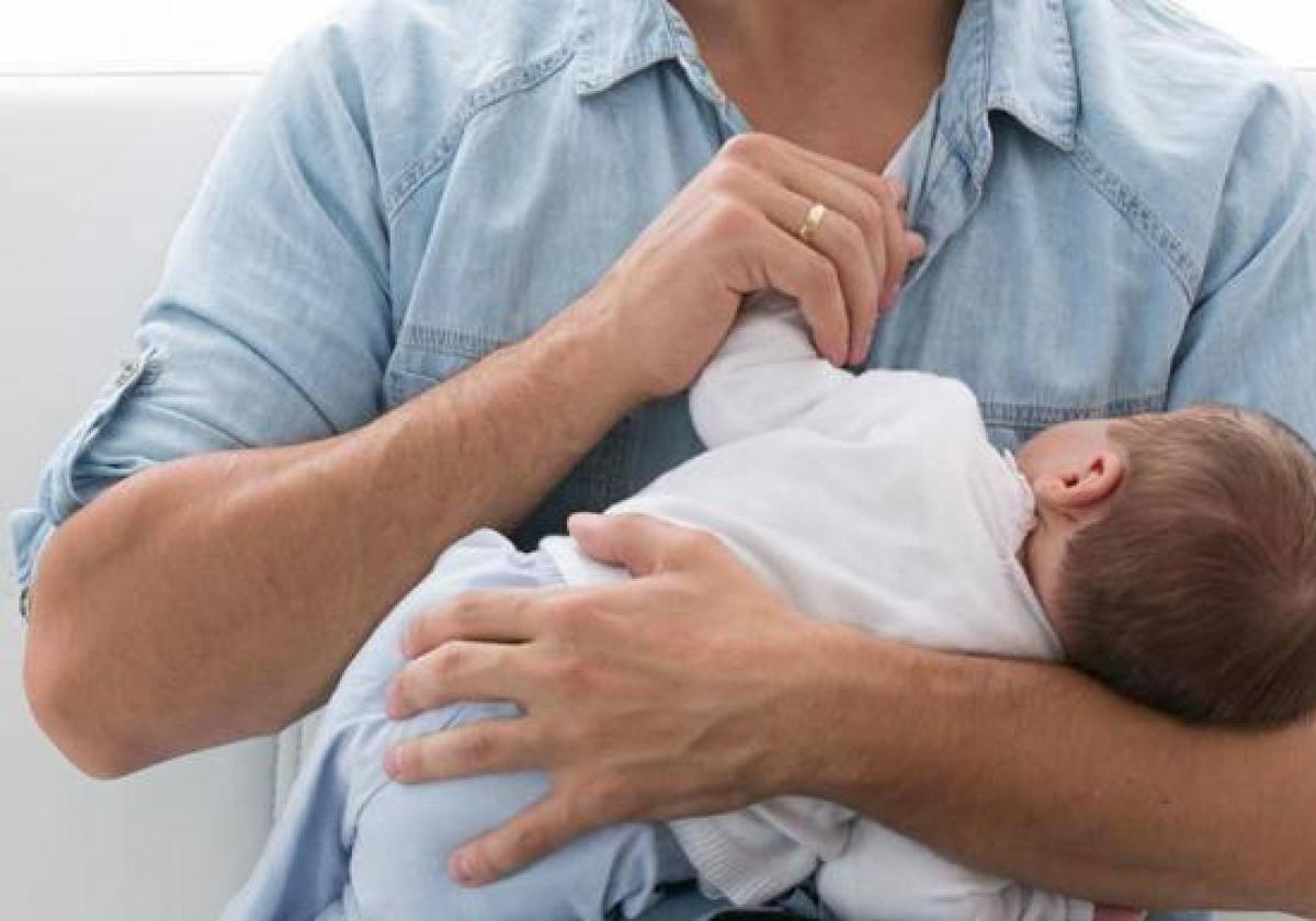 Imagen de archivo de un padre cogiendo a su bebé.