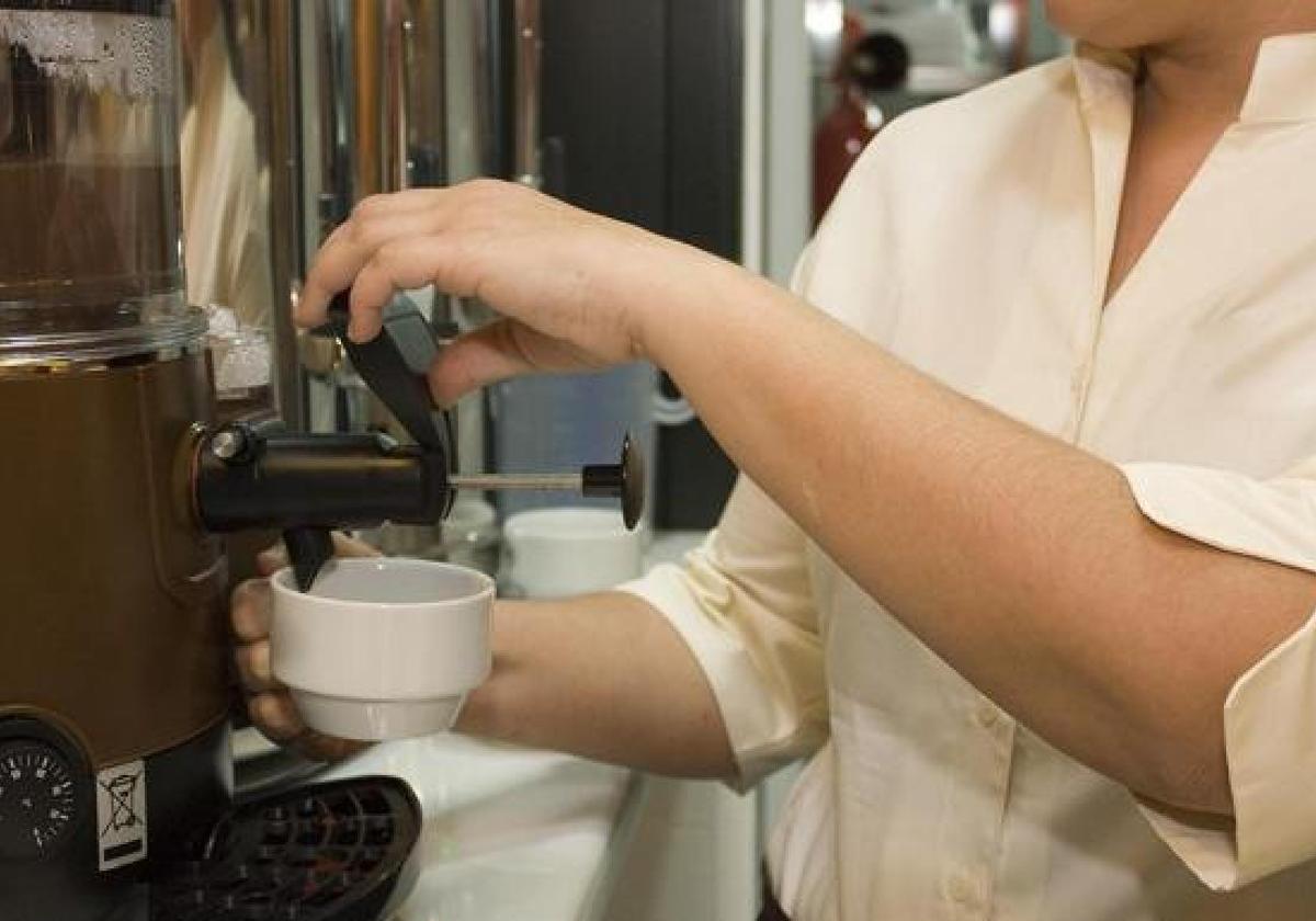 Un camarero sirve un café en un bar de León.