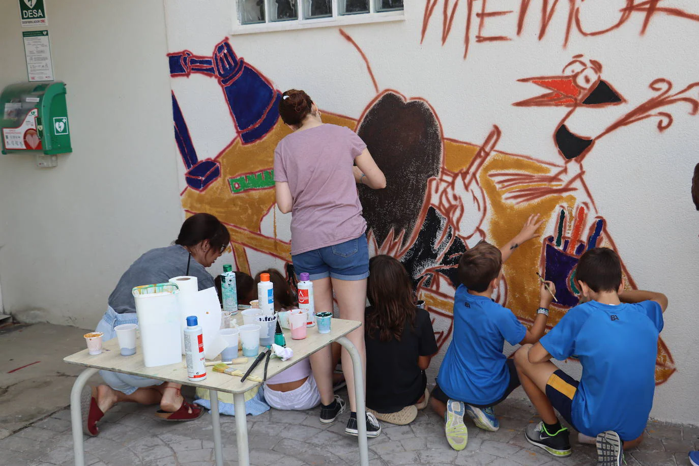 Parte del mural en la que aparece Lolo de espaldas dibujando