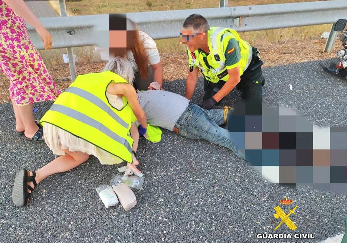 La Guardia Civil de Tráfico socorre a un motocicleta que había sufrido un accidente.