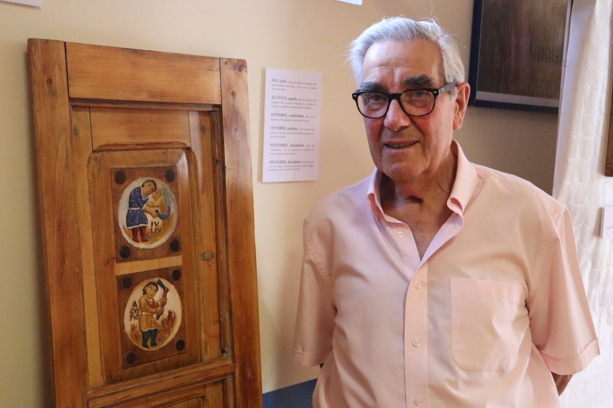 Pedro García junto a una talla de una ventana con el calendario agrícola 