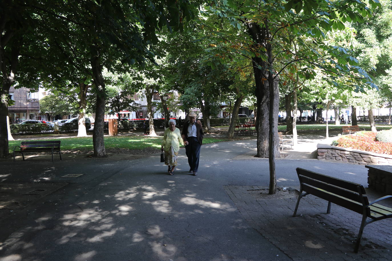 Dos personas mayores pasean por el parque de San Francisco.