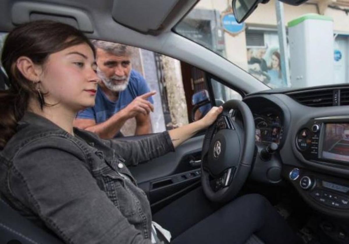 Un profesor de autoescuela muestra a la alumna algunos conceptos.