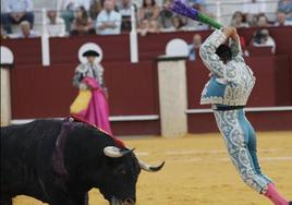 Un torero clavando banderas al astado.