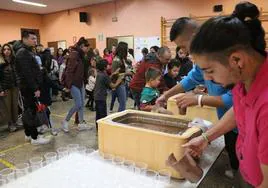 La peña Ceda el Vaso y Los Moraos repartiendo chocolate en el Salón del Pueblo.