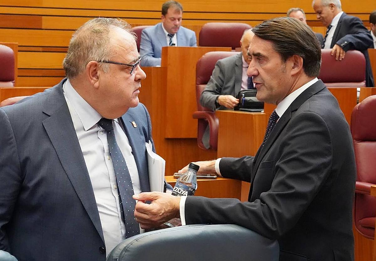 El consejero de Sanidad Alejandro Vázquez conversa con el consejero de Medio Ambiente Juan Carlos Suárez Quiñones en el pleno de las Cortes.