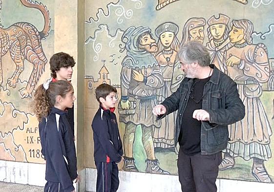 El profesor Jesús Palmero explica a alumnos del colegio Leonés la técnica del mural que Lolo dibujó en este centro.