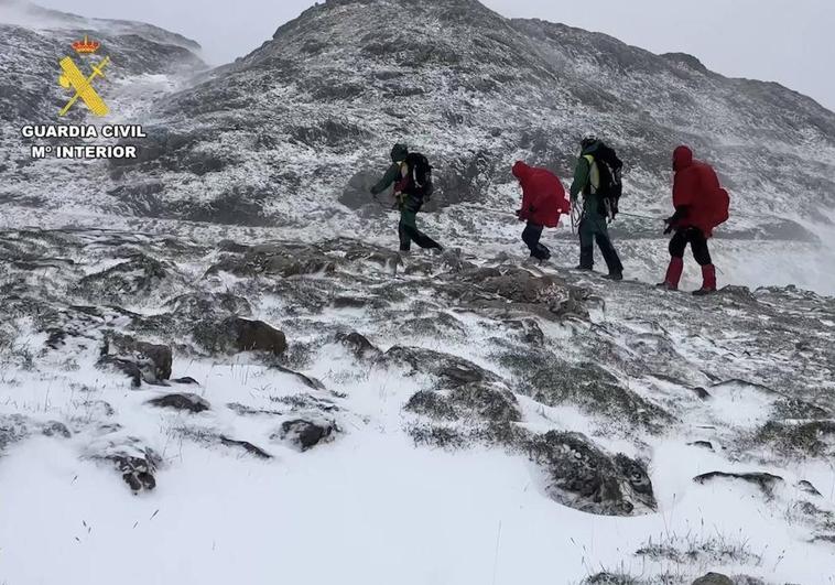 Montañeros bajando de la cima con equipos de protección