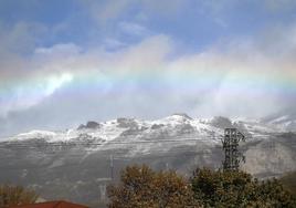 Un arcoíris sobre las montañas de León cubiertas de nieve.