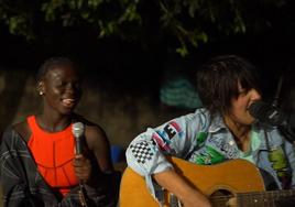 Jhana Beat toca la guitarra acompañada por una joven de la región de Camance.