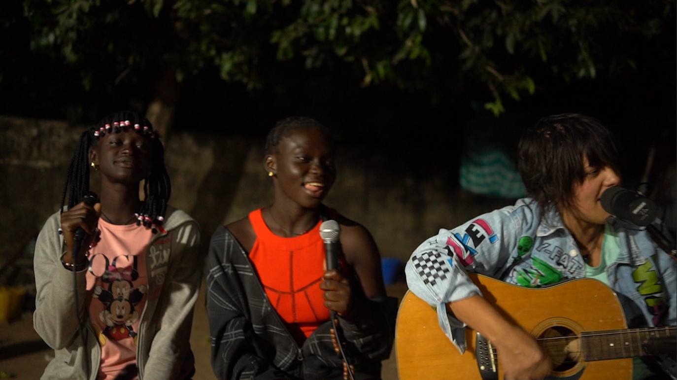 Jhana Beat toca la guitarra acompañada por una joven de la región de Camance.