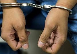 Un hombre es esposado por un delito.