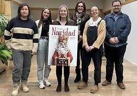 Miembros del jurado posan con el cartel ganador.