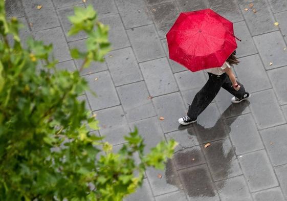 Una mujer camina con un paraguas un día de lluvia en una imagen de archivo.