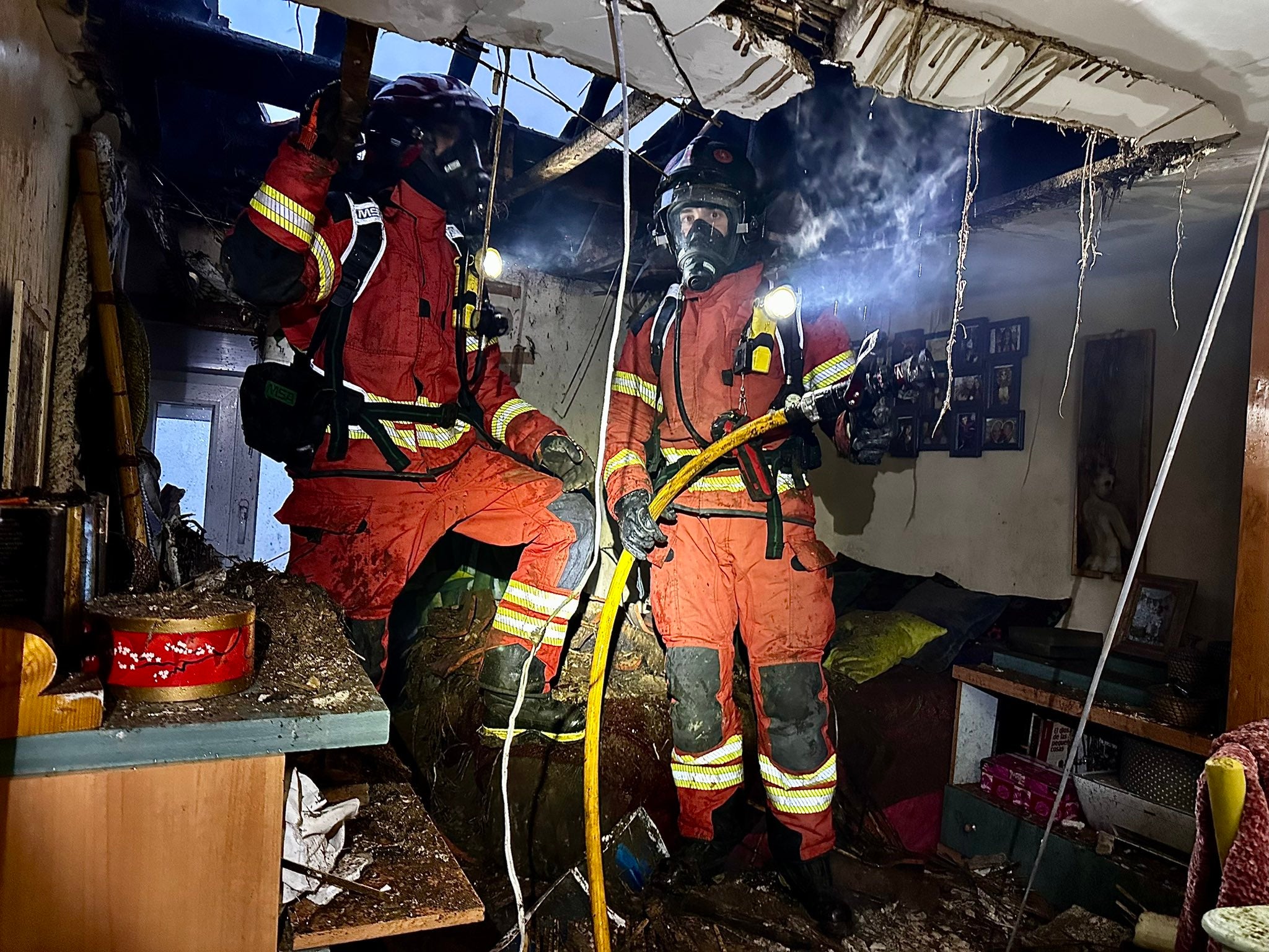 Dos bomberos durante la actuación en el interior de la vivienda.