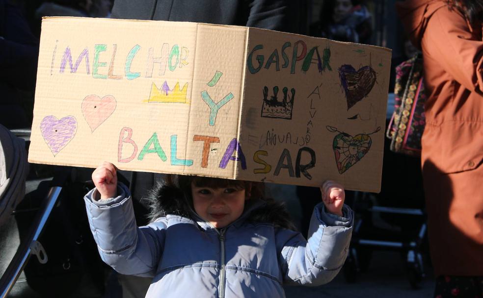 Los Reyes Magos llegan a bordo de un tren a la estación de León y son recibidos con pancartas.