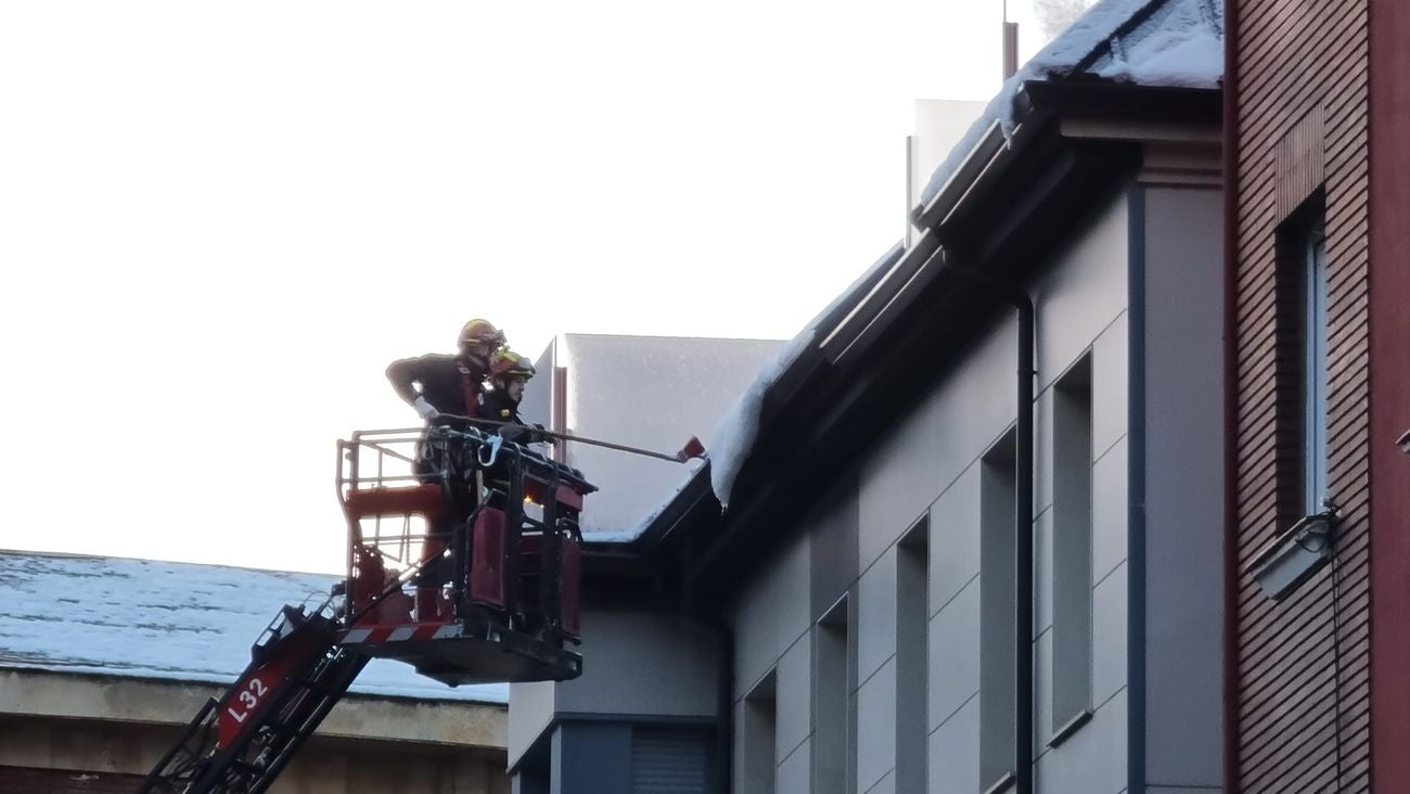 Bomberos interviene para retirar el hielo formado en varias viseras de nieve en inmuenbles de León. Efectivos del parque de Bomberos de León han intervenido para retirar la nieve de la techumbre de un inmueble en García I de la capital. 