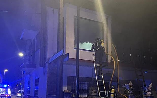 Los bobmeros trabajan en la extinción de las llamas en la vivienda.